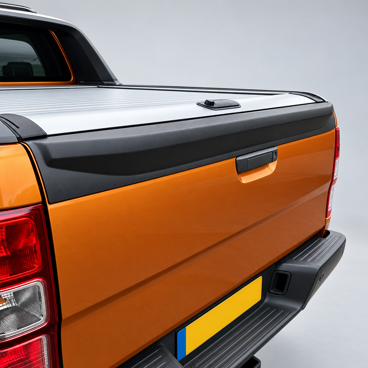 Textured black tailgate top cover installed on orange Ford Ranger